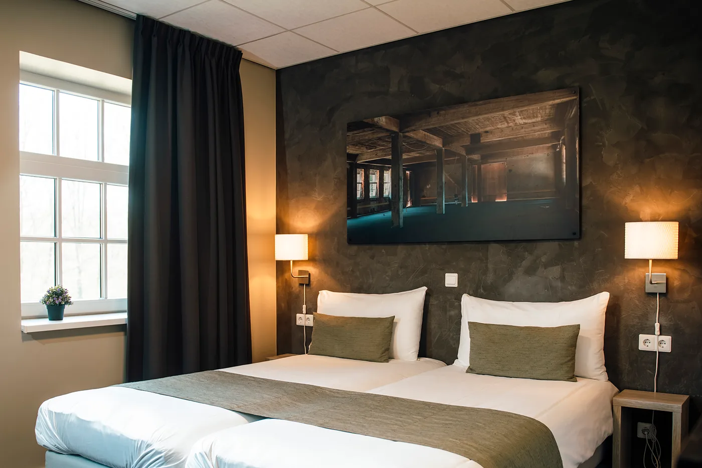 Een opgemaakte hotelkamer in De Kastanjefabriek
