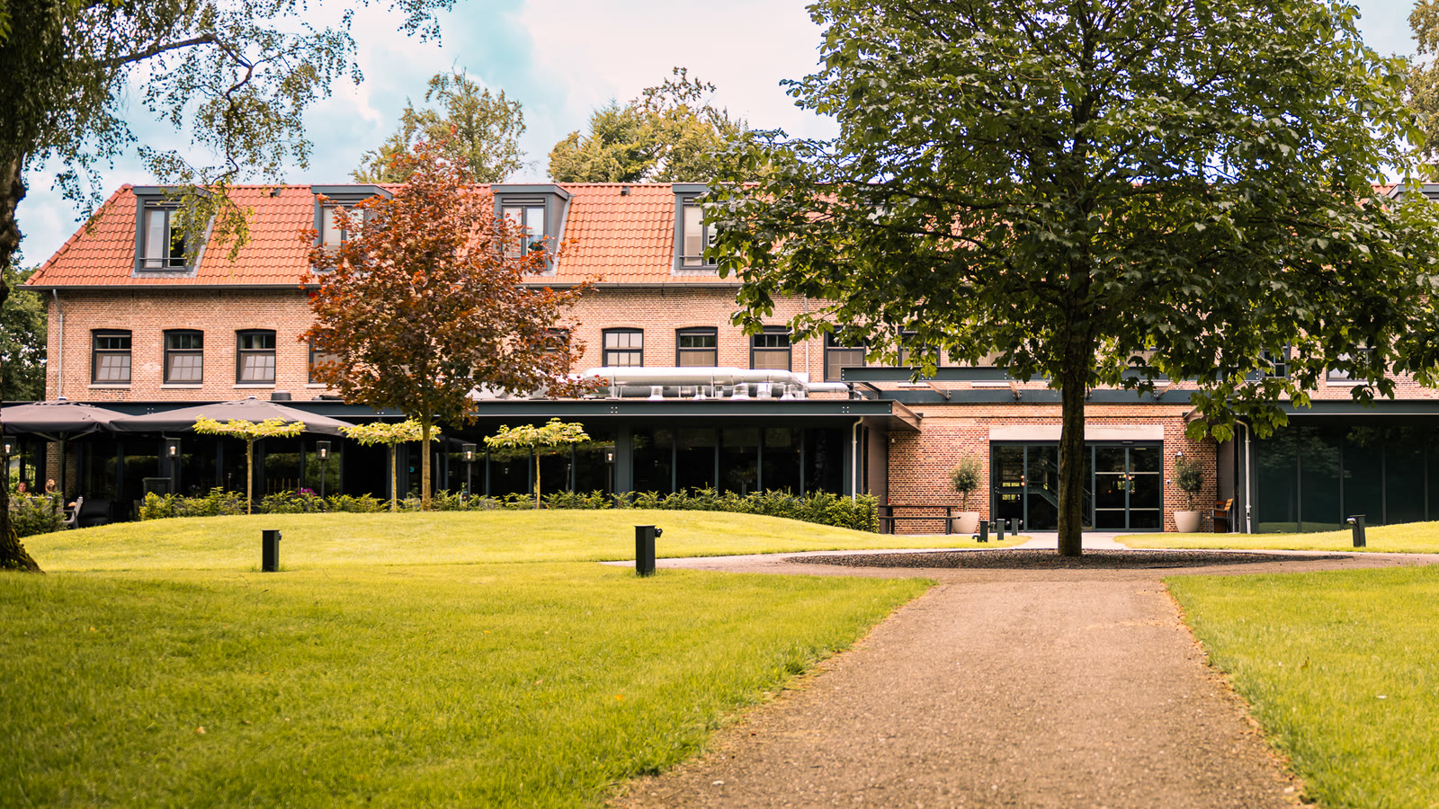 De Kastanjefabriek nu, gerestaureerd, met het gazon en de boom ervoor